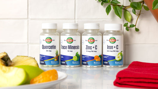 row of four supplement bottles on a kitchen counter